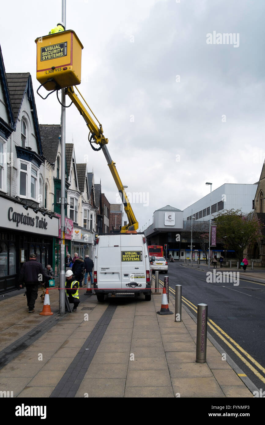 Systèmes de sécurité visuelle à l'aide d'entrepreneurs un palan hydraulique monté sur van pour installer une caméra de surveillance CCTV à un lampadaire Banque D'Images