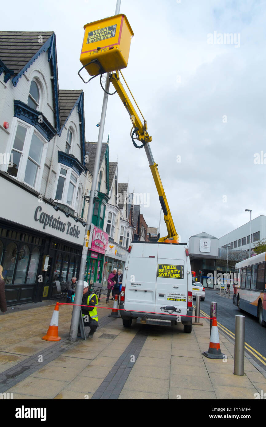 Systèmes de sécurité visuelle à l'aide d'entrepreneurs un palan hydraulique monté sur van pour installer une caméra de surveillance CCTV à un lampadaire Banque D'Images