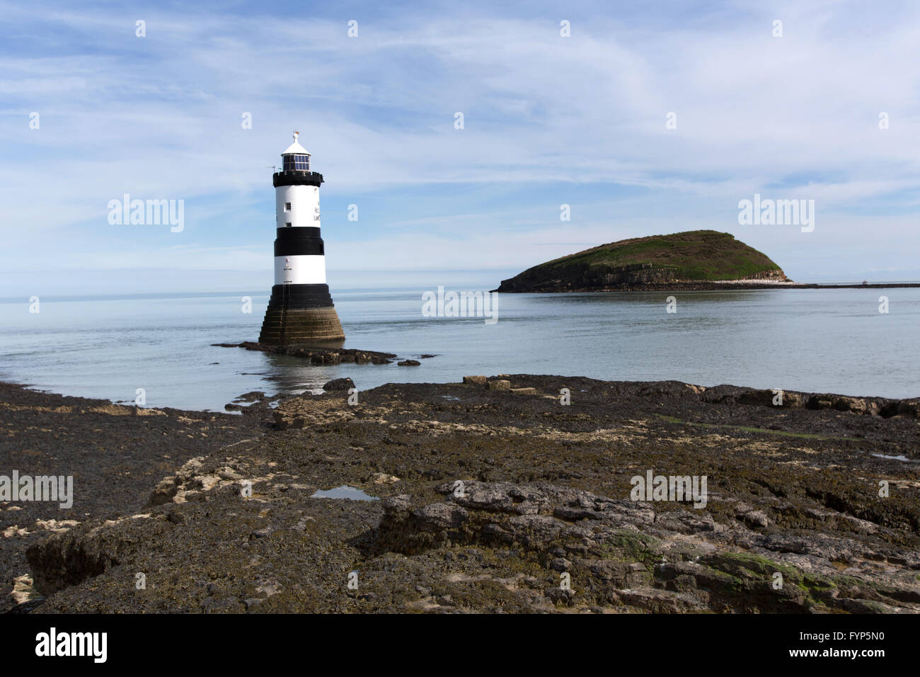 Vue pittoresque de Penmon Point Lighthouse, avec le détroit de Menai et île de macareux dans l'arrière-plan. Banque D'Images