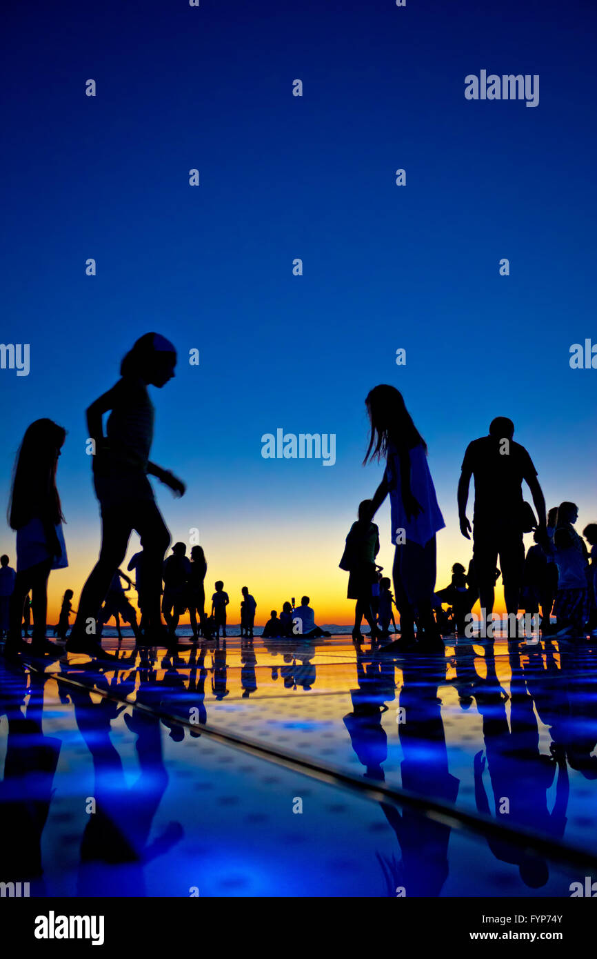 Les gens silhouette sur soleil colorés Banque D'Images