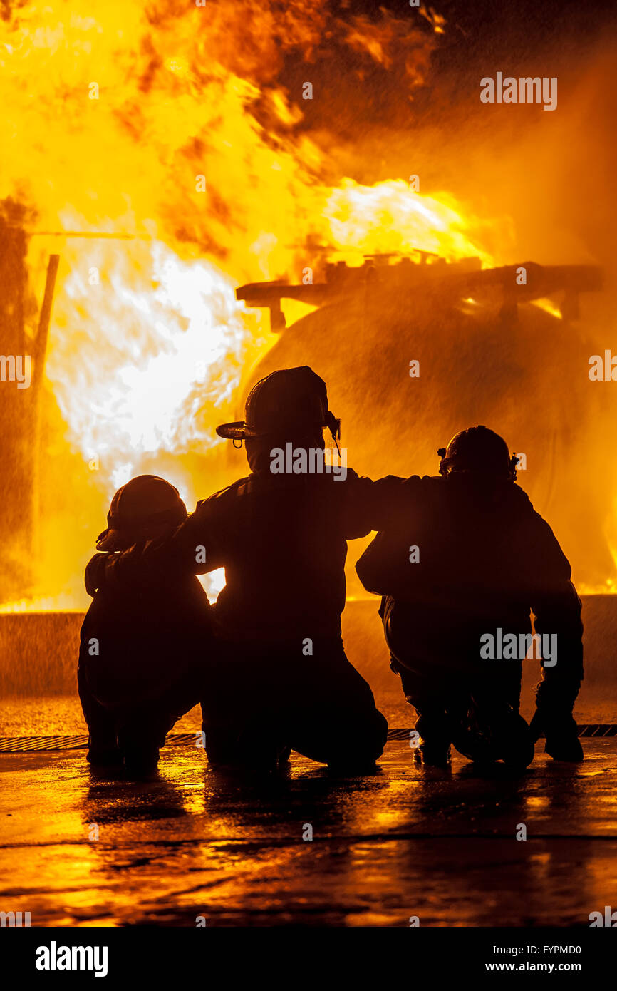 Les pompiers de regarder un feu brûler Banque D'Images
