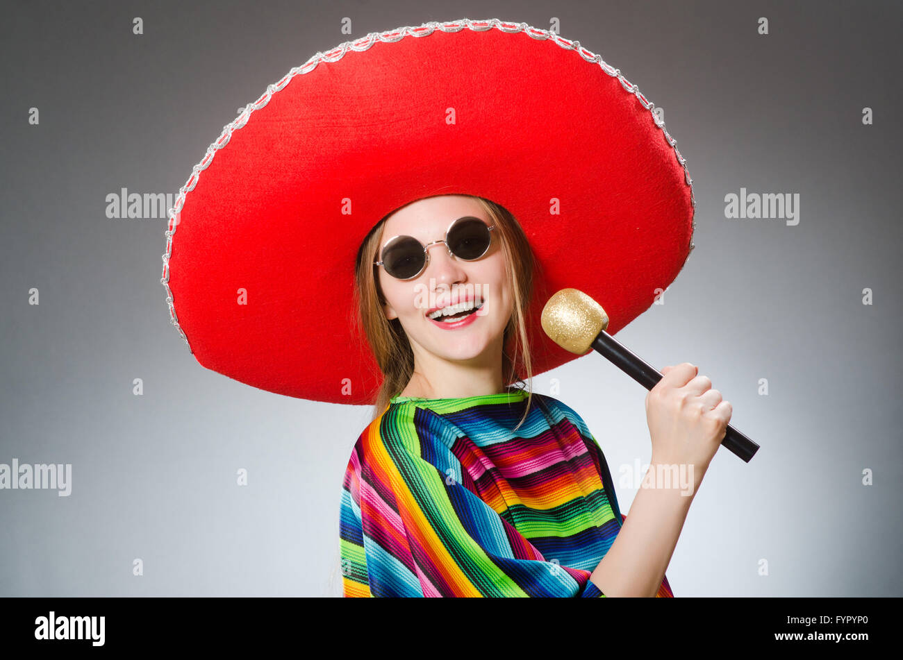 Fille de vivid mexicain poncho avec les maracas contre gray Banque D'Images