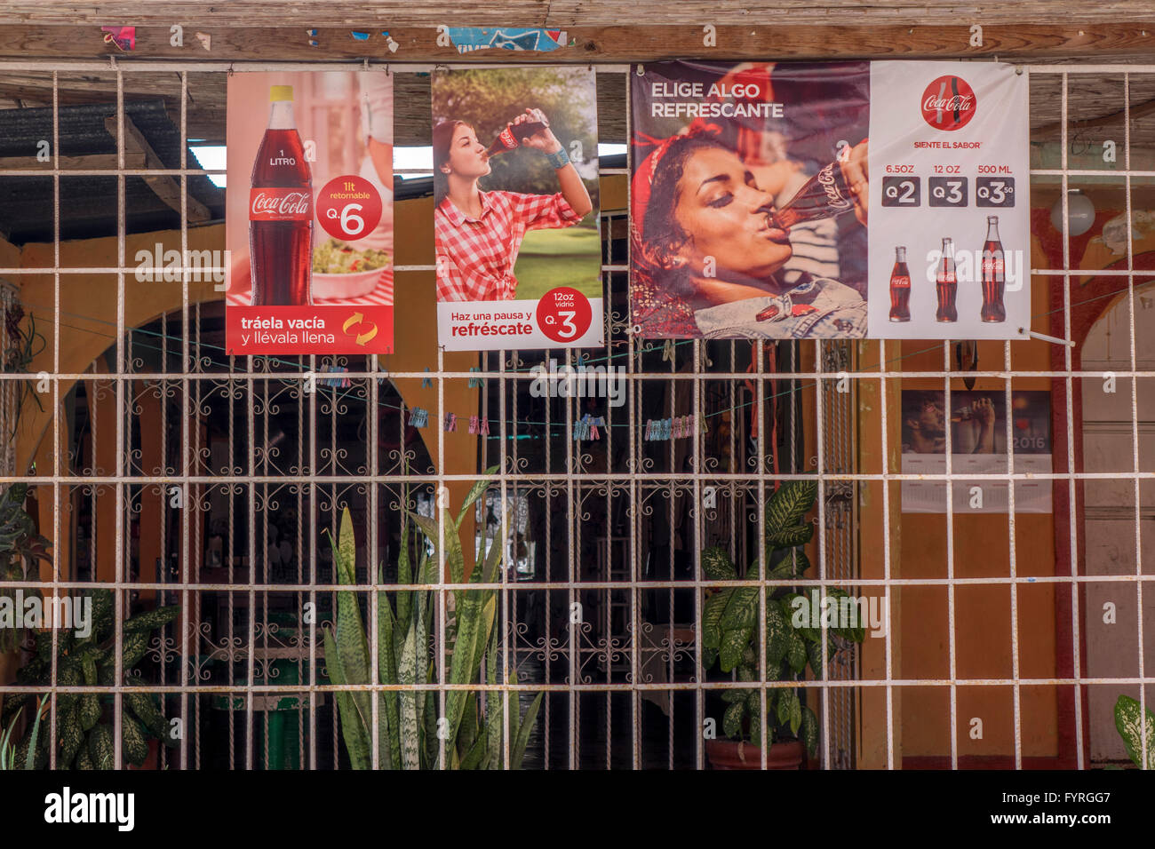 Langue Espagnol Coca Cola signes sur un magasin de commodité à Santo Tomas de Castilla, Guatemala Banque D'Images