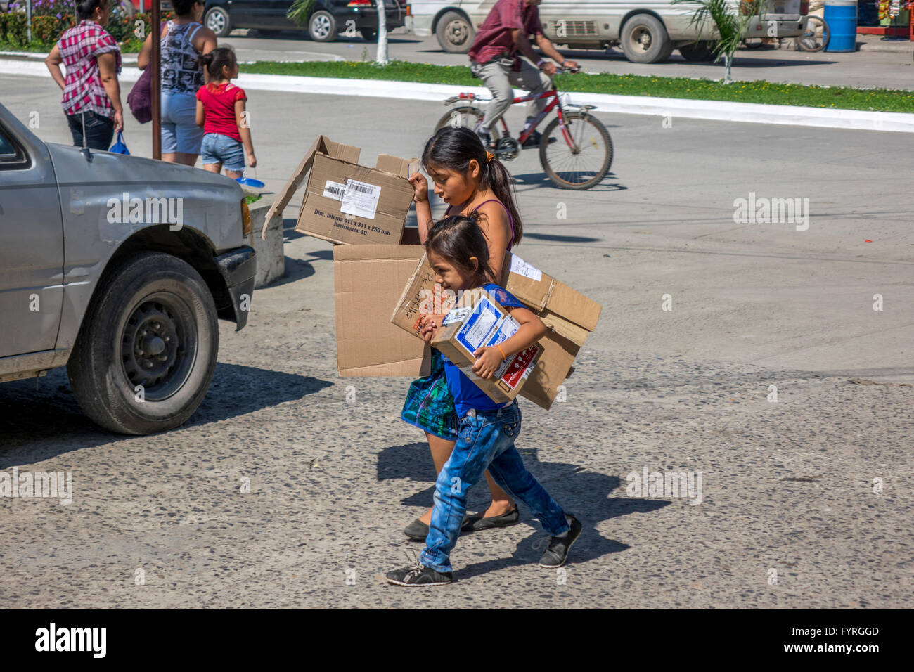 Deux jeunes Sœurs transportant des boîtes de carton au centre de la ville de Santo Tomas de Castilla Guatemala Amérique Centrale Banque D'Images
