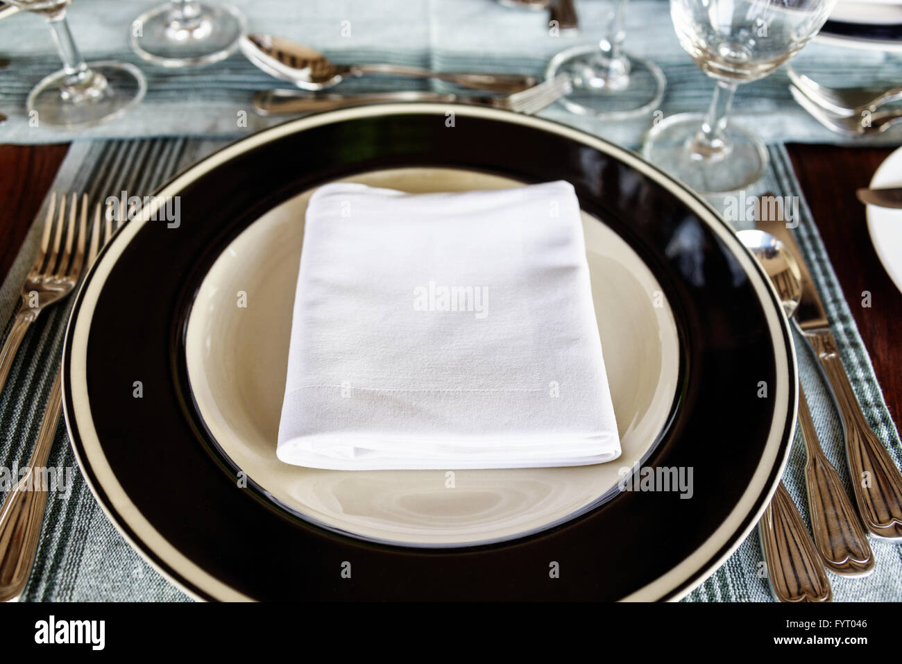 Vue perspective de la première personne sont soigneusement disposées sur une table à manger avec une serviette pliée au milieu de la plaque avec des ustensiles Banque D'Images