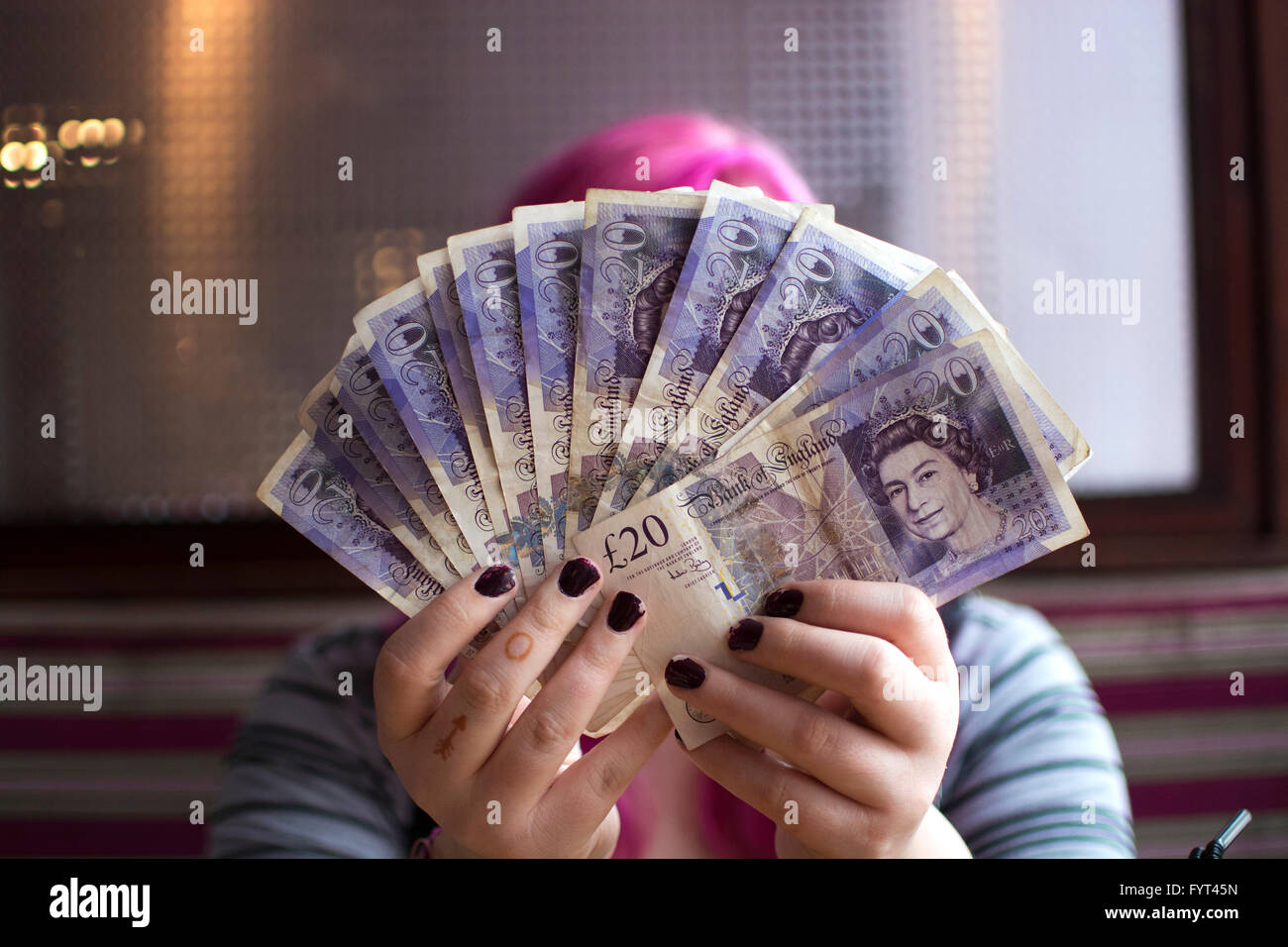 Image montrant student holding sa a récemment reçu en prêt étudiant £20 notes. Banque D'Images
