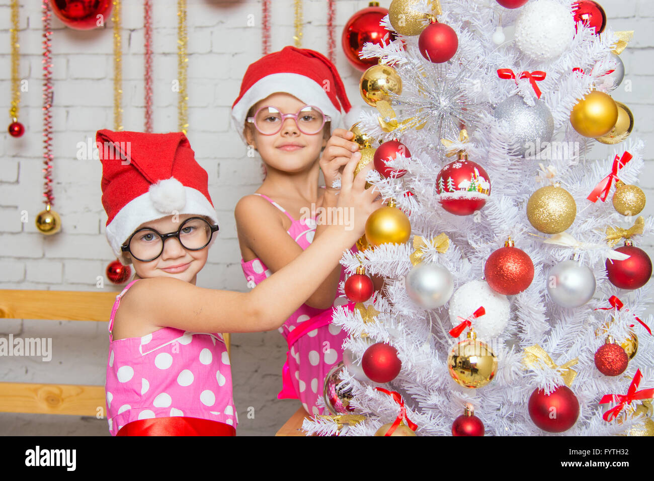 Deux funny girls hanging boules sur l'arbre de Noël Banque D'Images