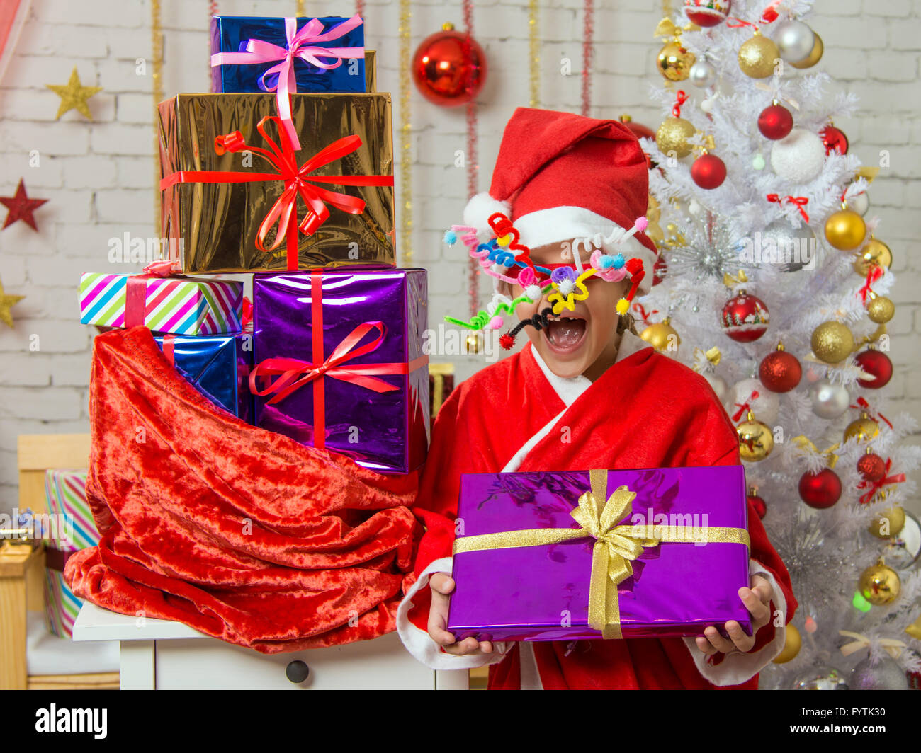 Fille avec du matériel roulant de l'artifice dans les yeux est un cadeau de sac de cadeaux de Noël Banque D'Images