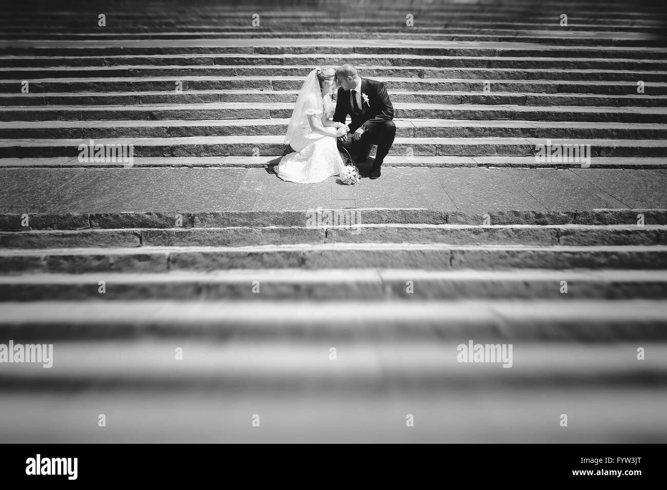 Récemment Mariés couple sitting on stairs Banque D'Images