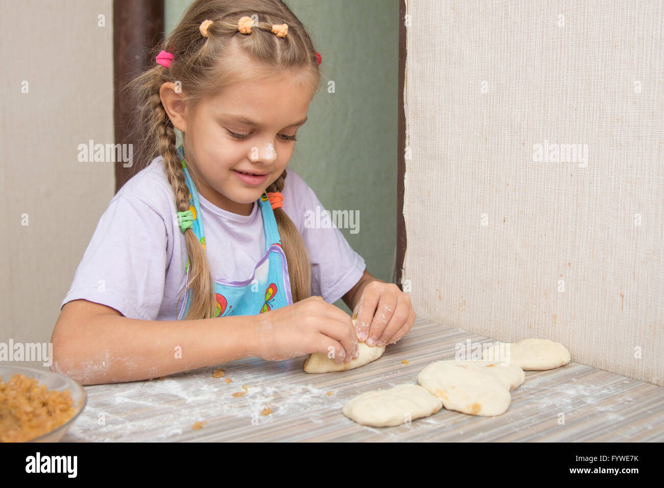 Cheerful fillette de six ans sculpte les gâteaux avec le chou Banque D'Images