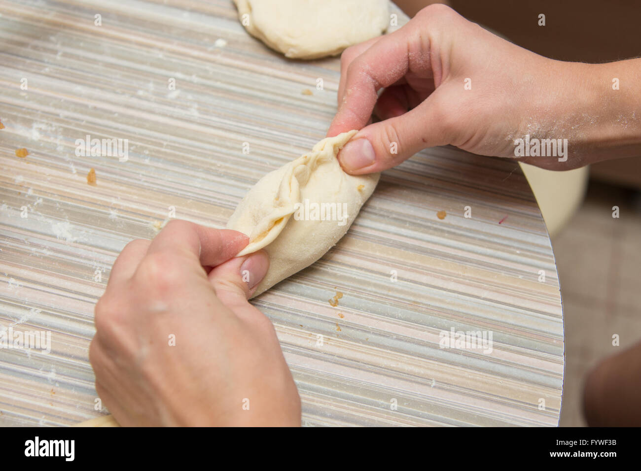 Gâteau à la main féminine sur la table de cuisine Banque D'Images