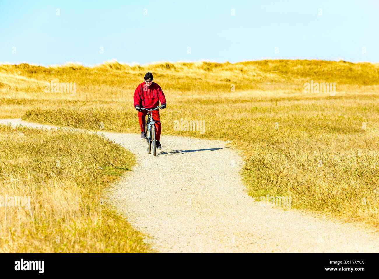 La Suède, Falsterbo - Avril 11, 2016 : Hommes adultes à vélo le sentier de randonnée Skaneleden sur une partie sinueuse à la côte avec de gr Banque D'Images