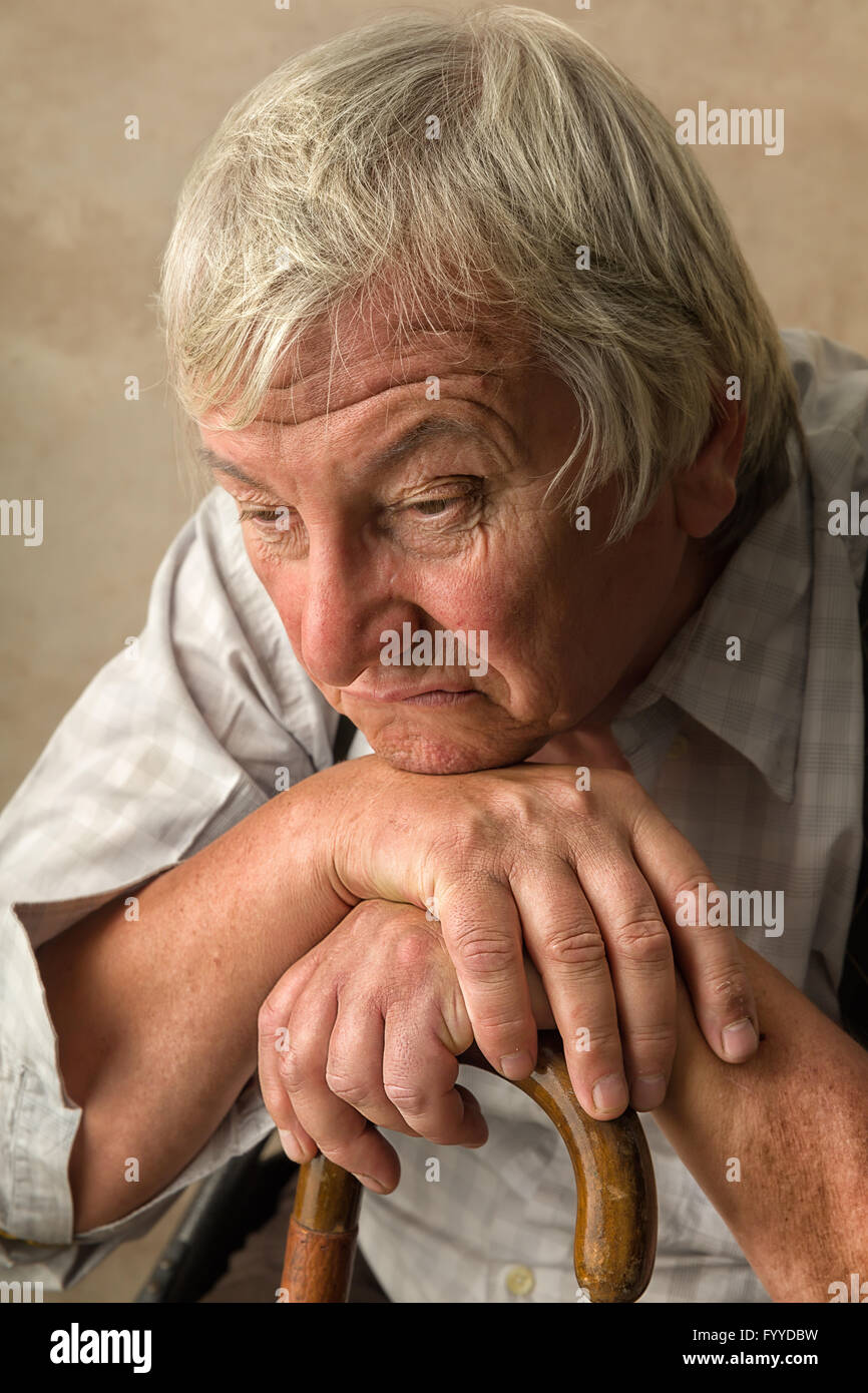 Vieil homme solitaire dans la maison de soins infirmiers s'appuyant sur sa canne Banque D'Images