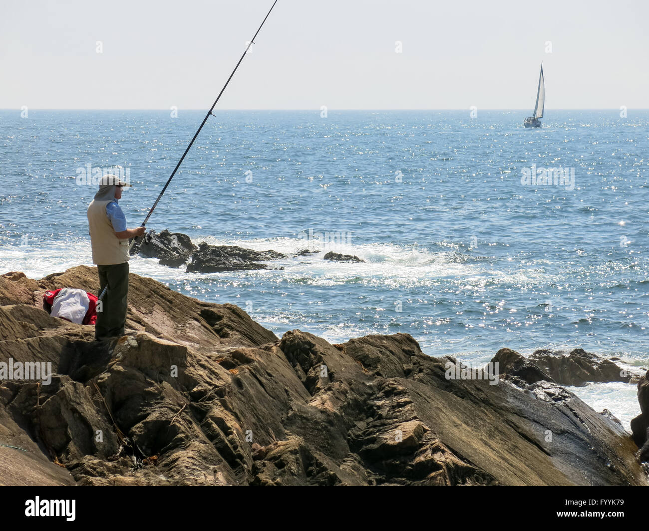 Pêcheur la pêche dans l'océan Atlantique et voilier naviguant au large des côtes de Foz près de Porto, Portugal Banque D'Images