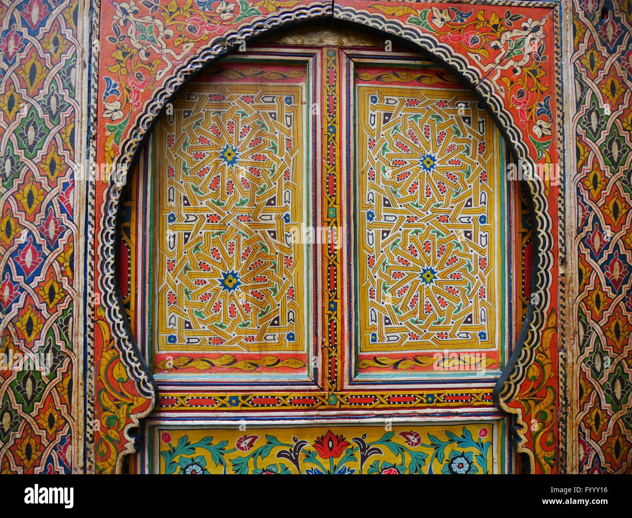 De façon complexe, à motifs traditionnels, des portes peintes de couleurs vives à Fez, Maroc.Les motifs floraux sont en rouge, jaune, bleu, vert Banque D'Images