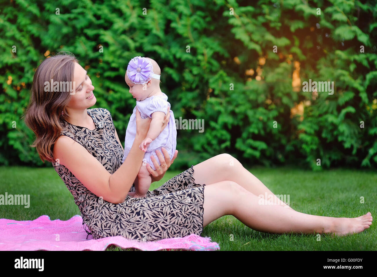 Maman détient sur les mains d'une petite fille en plein air park Banque D'Images