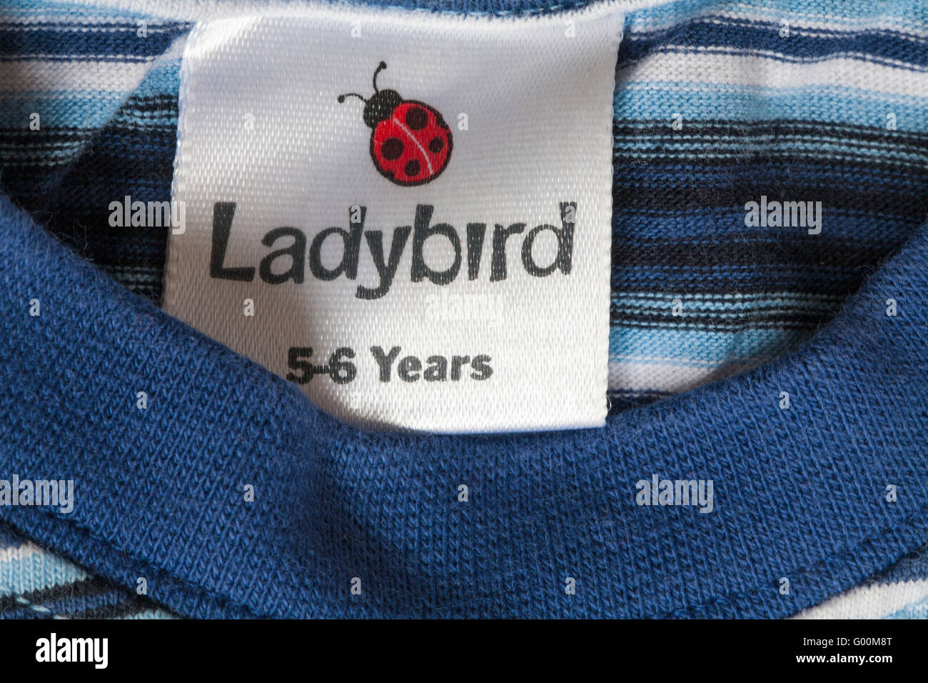 5-6 ans de l'enfant dans l'étiquette Coccinelle t-shirt à rayures Banque D'Images