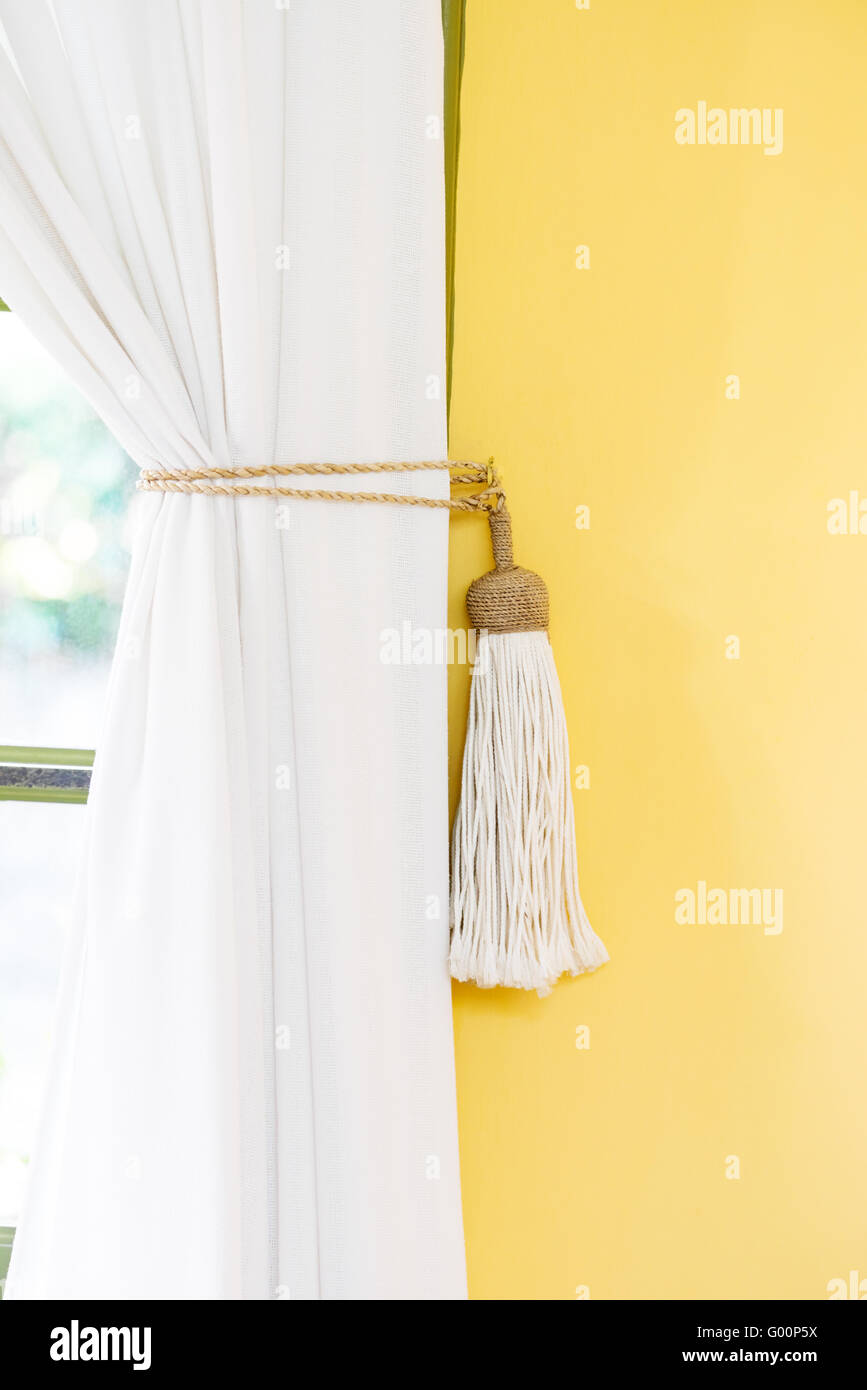 Rideau blanc embrasse décoration d'intérieur style simple mur jaune Banque D'Images