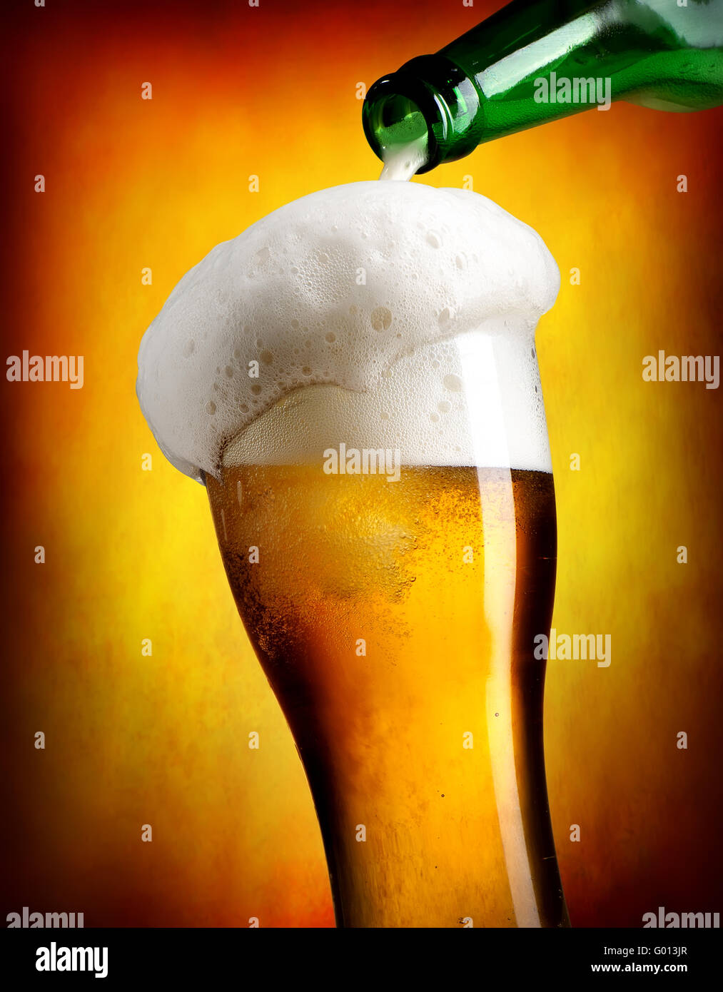 Verser la bière en bouteille à tumbler sur fond orange Banque D'Images