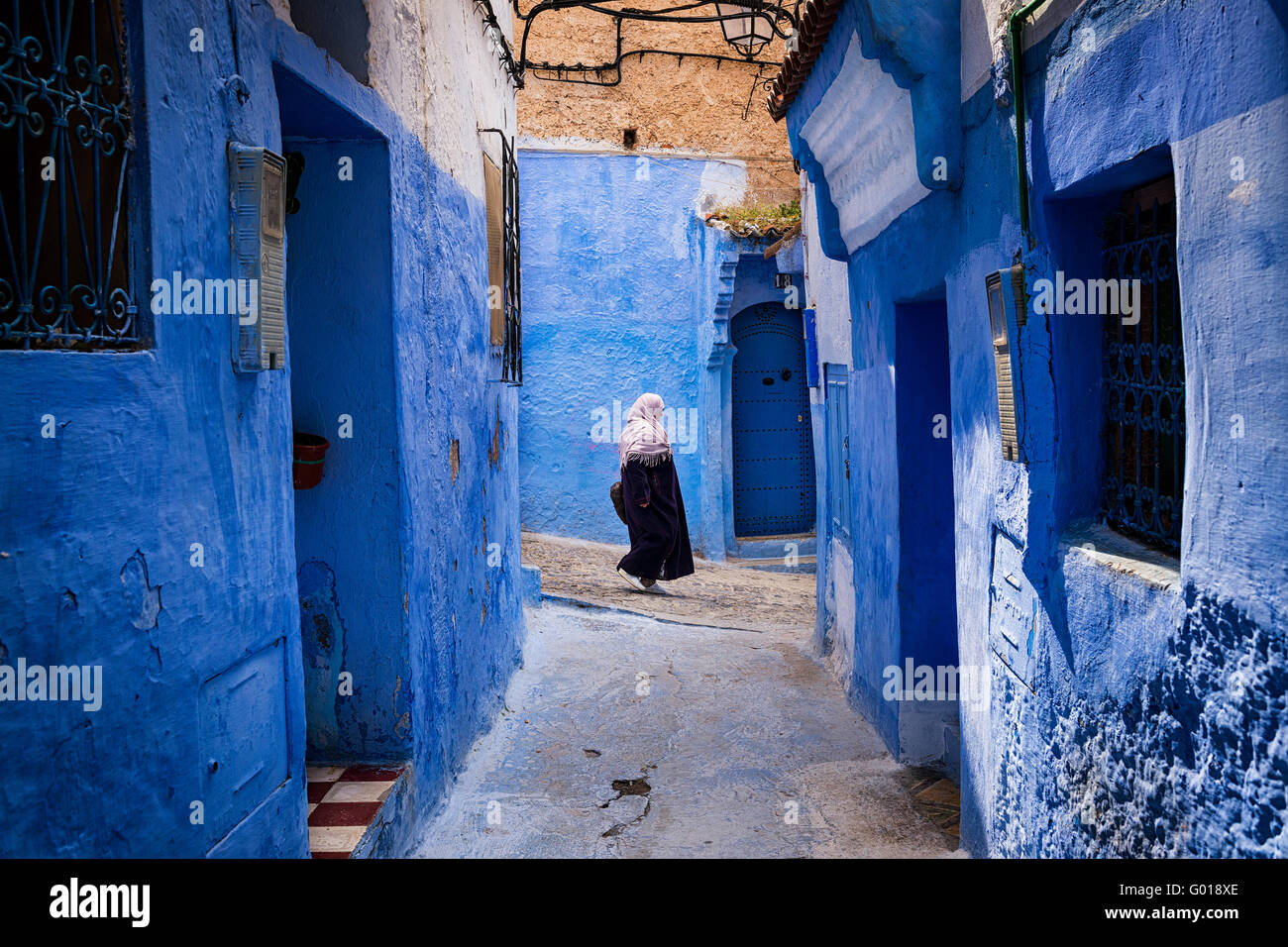 Chefchaouen, Maroc - 10 Avril 2016 : une femme marche dans une rue de la ville de Chefchaouen au Maroc. Banque D'Images