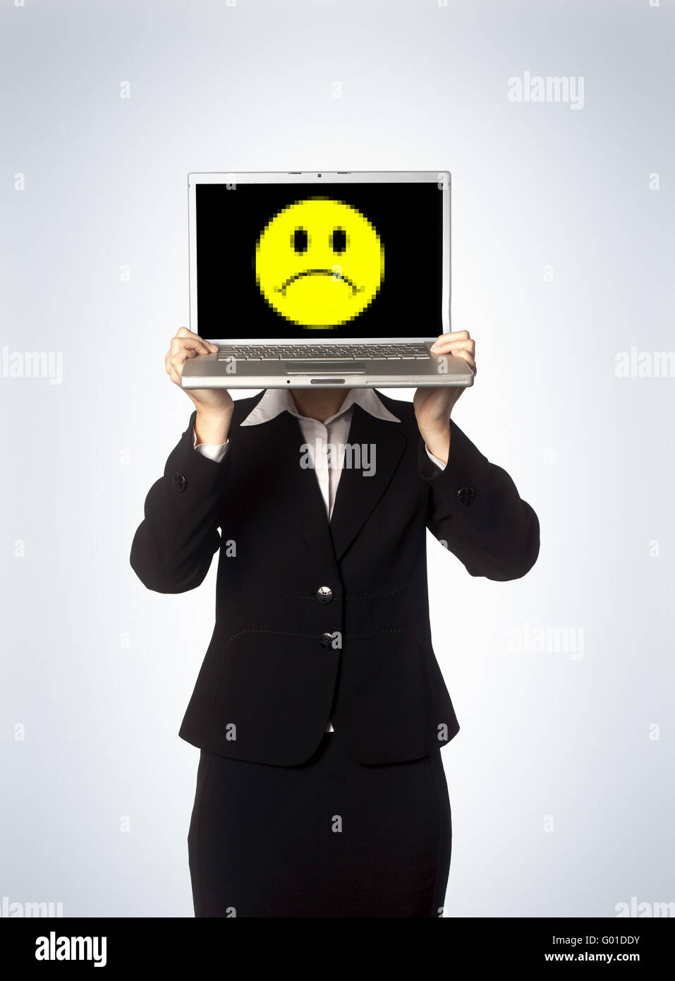 Une femme business woman holding up un ordinateur portable affichant un visage mécontent. Banque D'Images