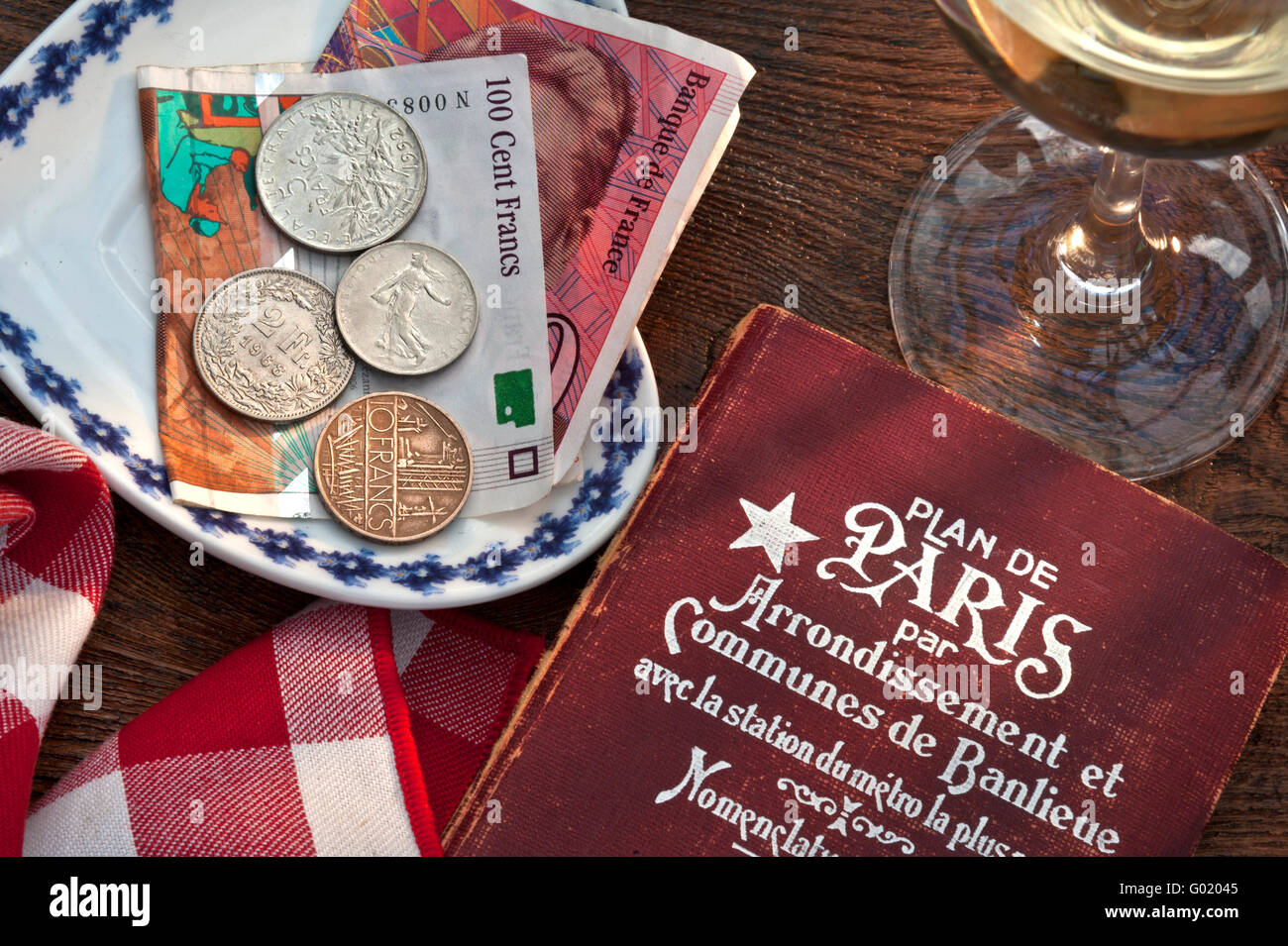 Années 1960-1970 Retro French Restaurant café , style Art déco Paris guide livre, Francs français, verre à vin sur table ensoleillée concept pré-euro Voyage France Banque D'Images