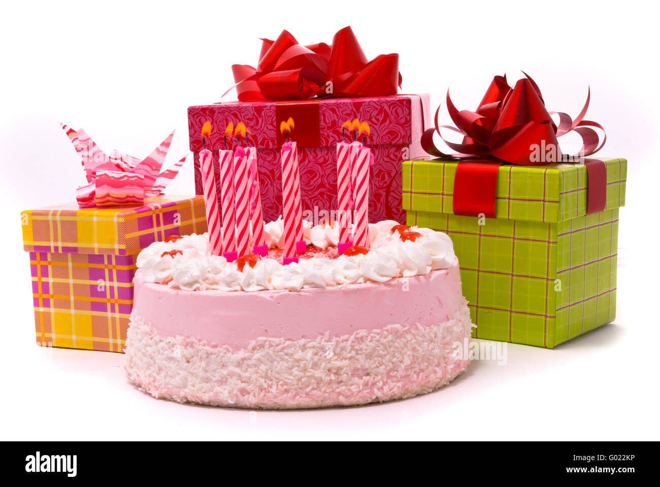 Gâteau rose avec 9 bougies et cadeaux dans des boîtes sur un fond blanc Banque D'Images