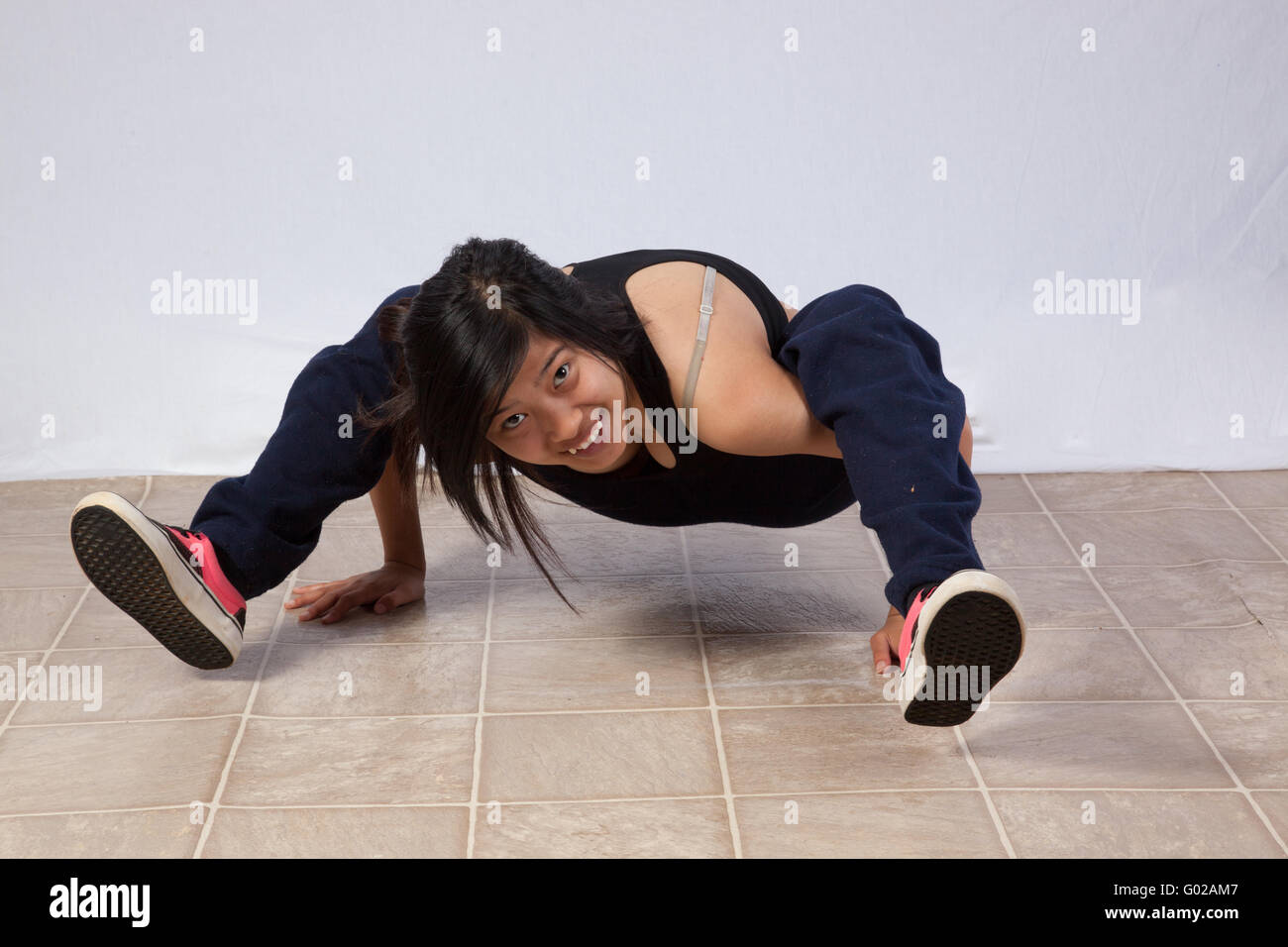 Pretty woman in sports bra break-dancing et à l'appareil photo à pensivement Banque D'Images