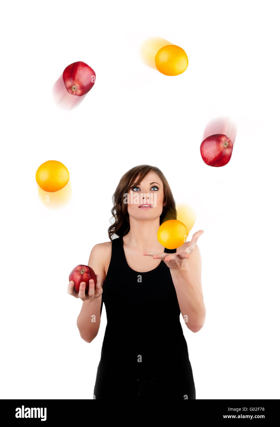 Belle femme jonglant avec des pommes et des oranges sur un w Banque D'Images