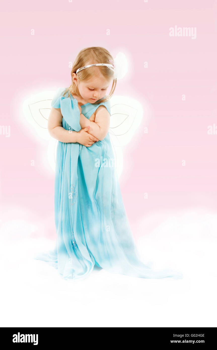 Fantaisie avec petite fille de 2.5 dans une robe longue sur un nuage Banque D'Images