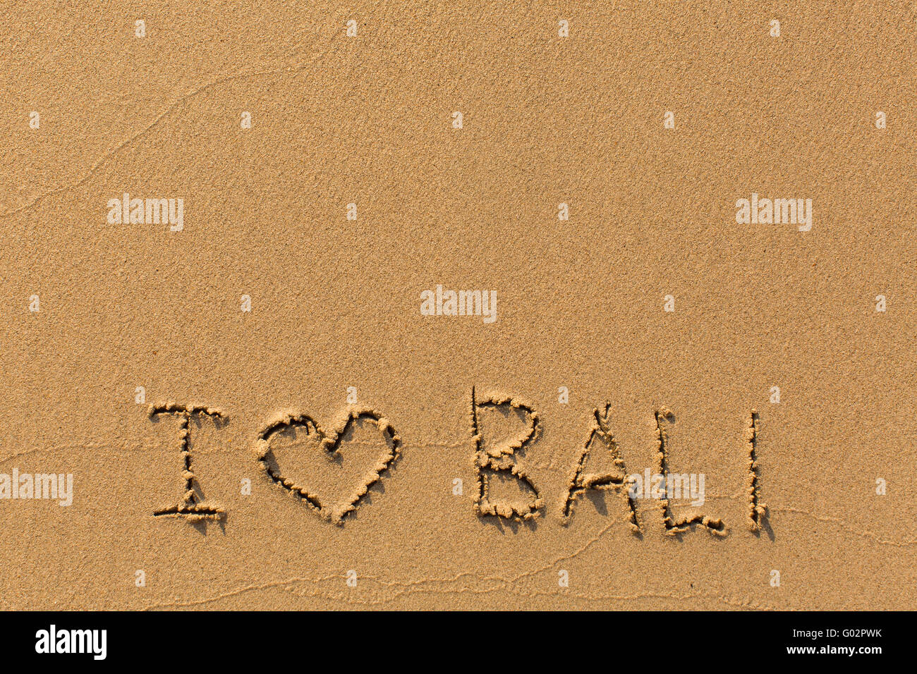 J'adore Bali - l'inscription à la main sur la plage de sable. Banque D'Images