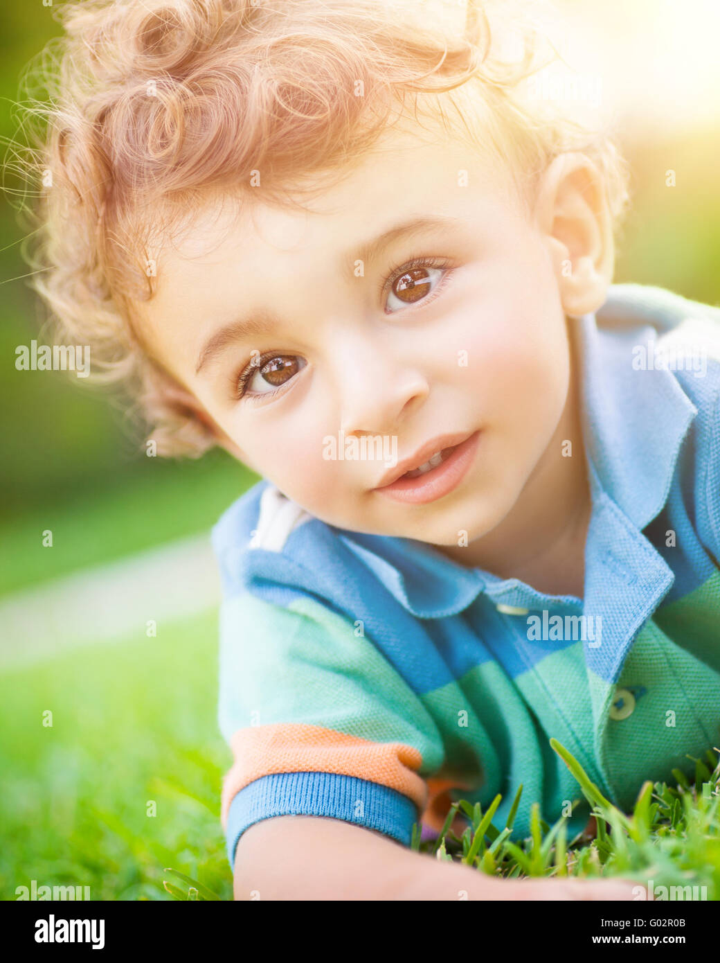 Closeup portrait of a cute little baby boy couché sur l'herbe, s'amuser  dans le parc, les dépenses des vacances en plein air Photo Stock - Alamy
