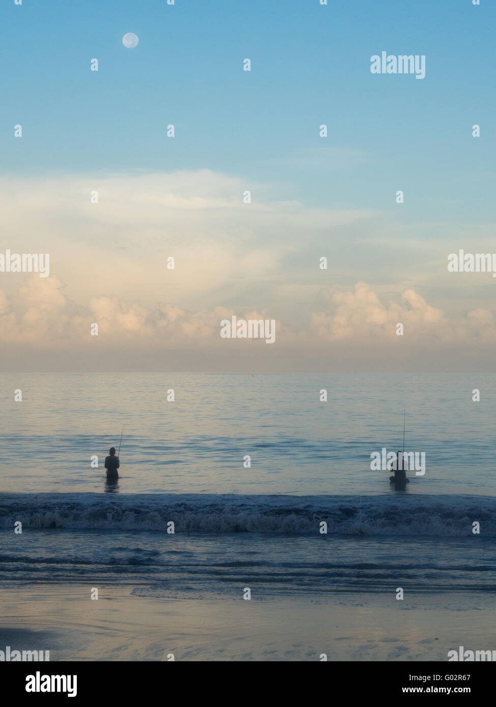 Deux pêcheurs dans la baie de Jimbaran, Bali, tôt le matin. Banque D'Images