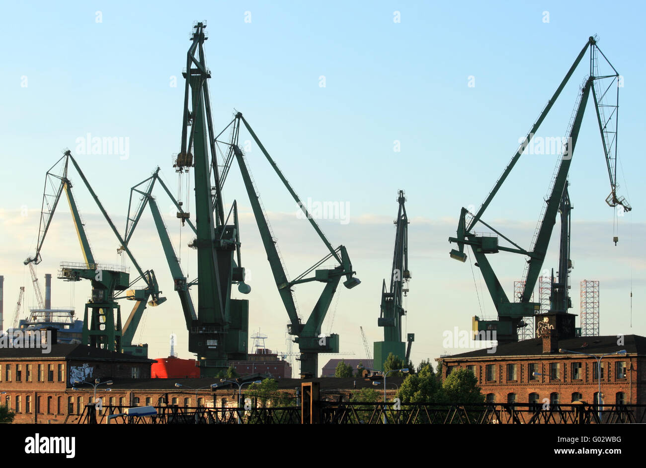 Silhouettes de grues portuaires et les bâtiments industriels à l'historique chantier naval de Gdansk Banque D'Images