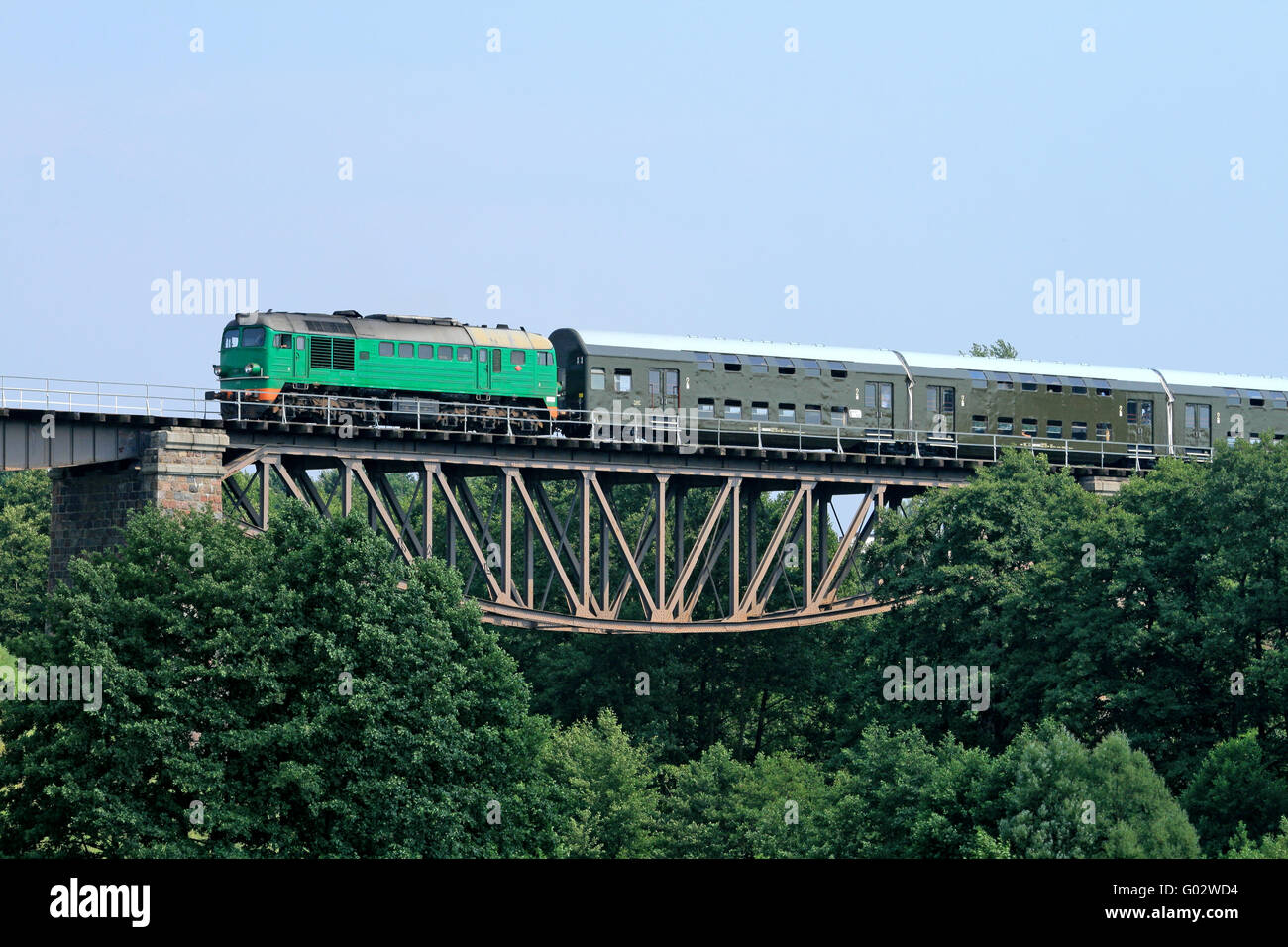 Train de voyageurs passant par le grand pont en acier Banque D'Images