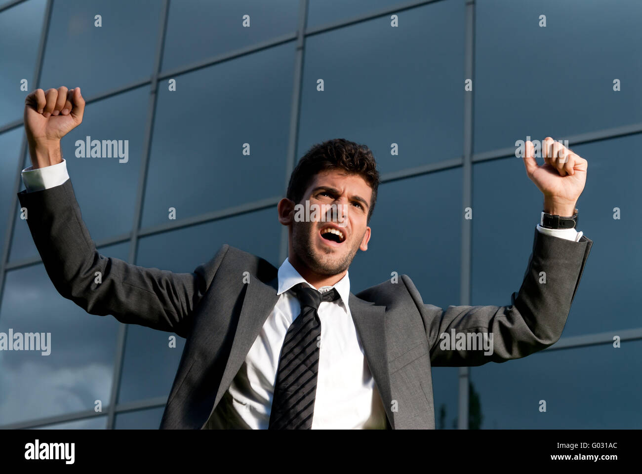 Jeune homme célébrant un but sur un bâtiment moderne Contexte Banque D'Images