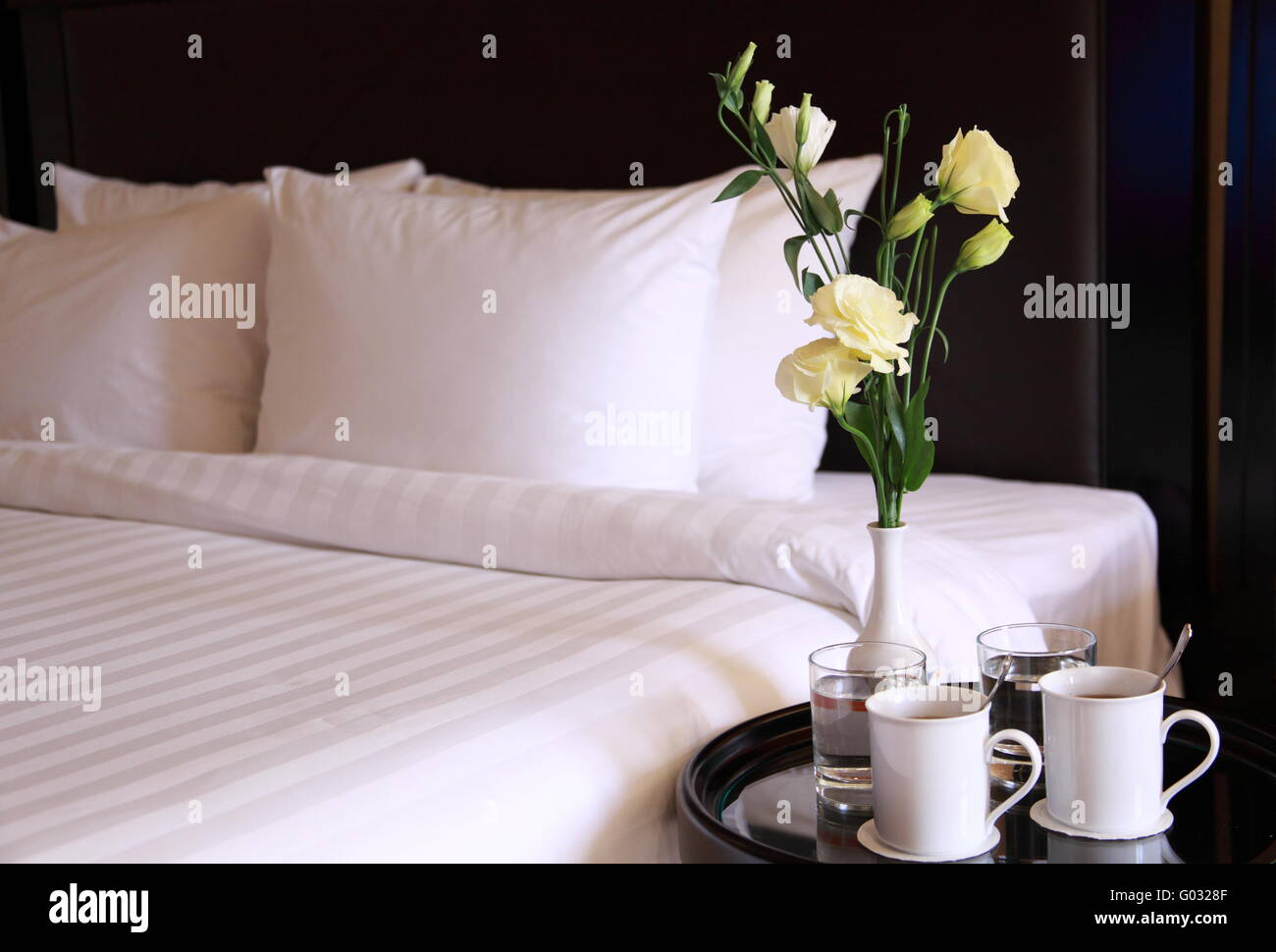 Chambre d'hôtel avec les tasses de café et de fleurs Banque D'Images