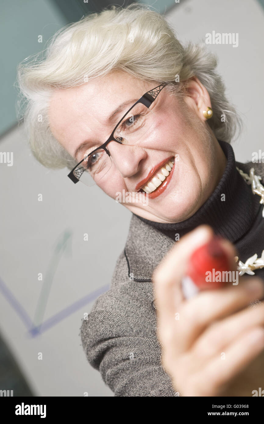 Senior business woman pointing avec un stylo Banque D'Images