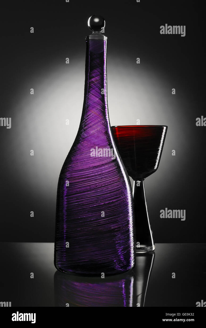 Bouteille vide avec du verre sur fond noir avec tache blanche Banque D'Images