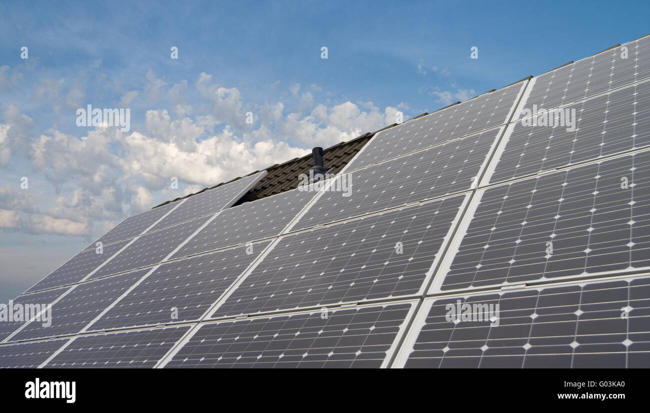 Des panneaux solaires sur toit de maison et quelques nuages Banque D'Images