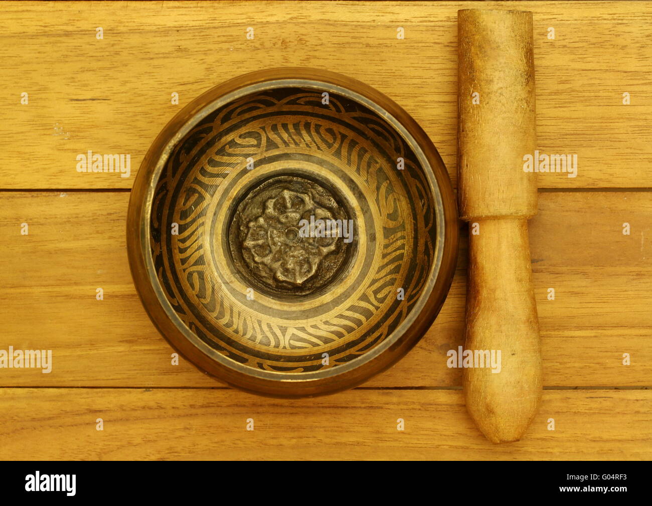 Bol chantant tibétain prise depuis le sommet, sur une table en bois de teck. Banque D'Images