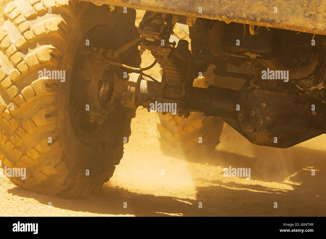 Vue détaillée des roues, pneus de camion qui va de l'arbre et dans la poussière du désert. Banque D'Images