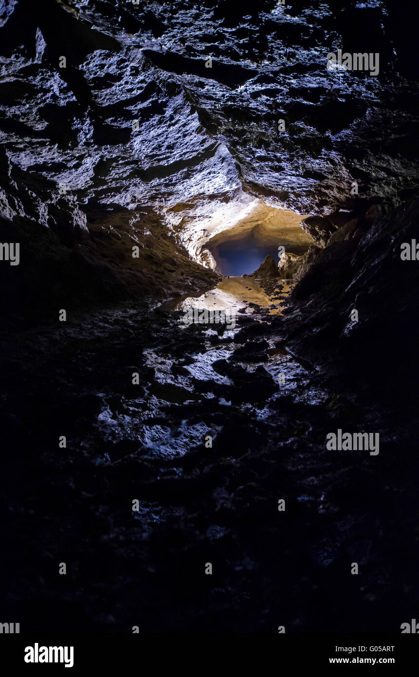 La lumière à l'entrée d'une grotte sombre Banque D'Images