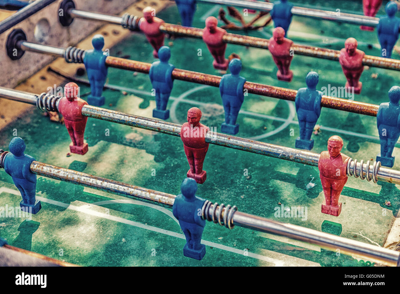 Détails de table rouge et bleu, les joueurs de football dummy sale et rouillé, couvert de feuilles et de poussière Banque D'Images
