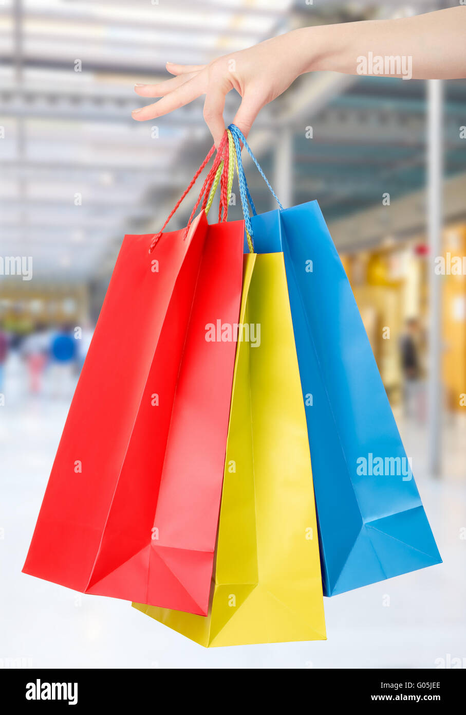 Woman holding shopping bags avec arrière-plan centre commercial Banque D'Images