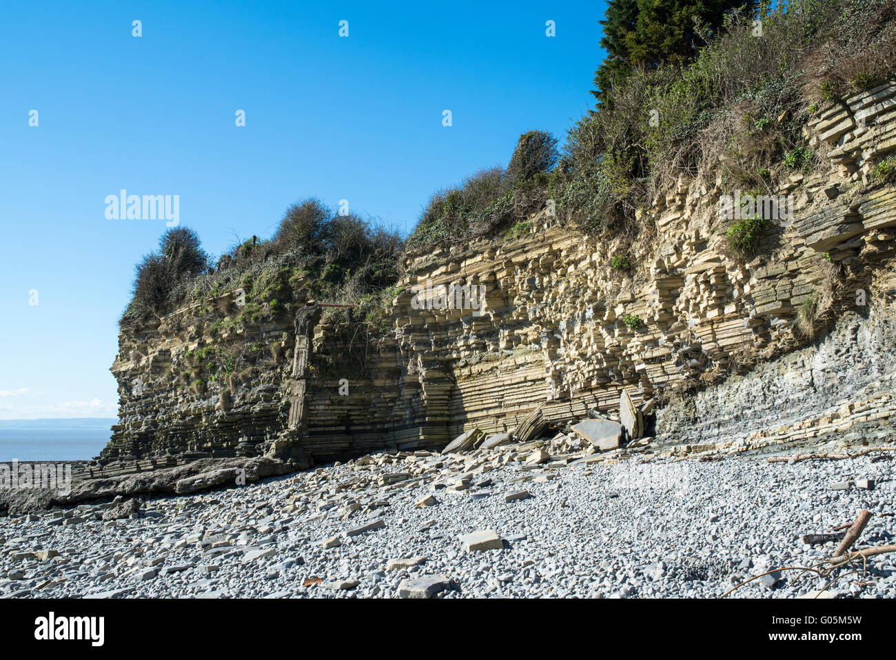 Falaise surplombant une plage de galets. Lavernock Point, Nouvelle-Galles du Sud. Banque D'Images