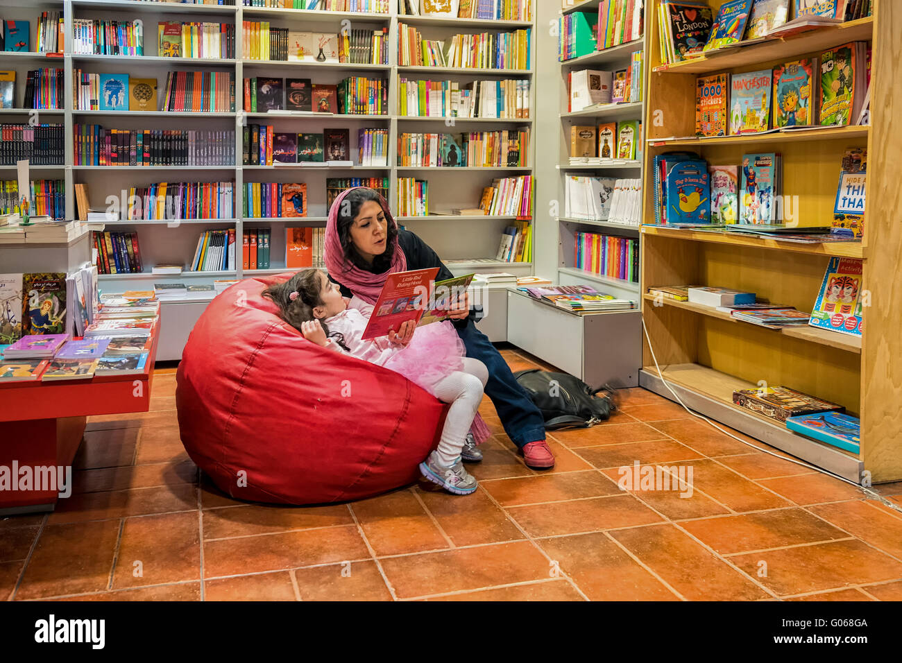 Lecture de la mère à sa fille dans le département de l'enfance d'un magasin de livre moderne à Téhéran, Iran. Banque D'Images