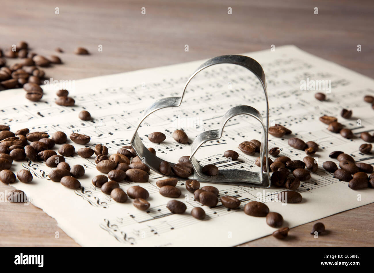 Les grains de café et coeur sur partitions et table en bois Banque D'Images