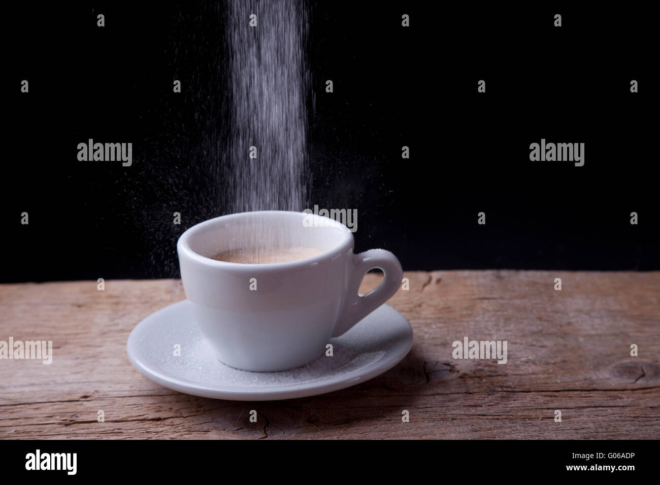 Le café avec du sucre qui se déverse sur la table en bois Banque D'Images