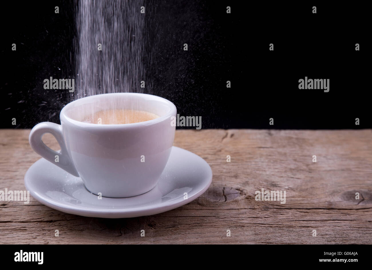 Le café avec du sucre qui se déverse sur la table en bois Banque D'Images